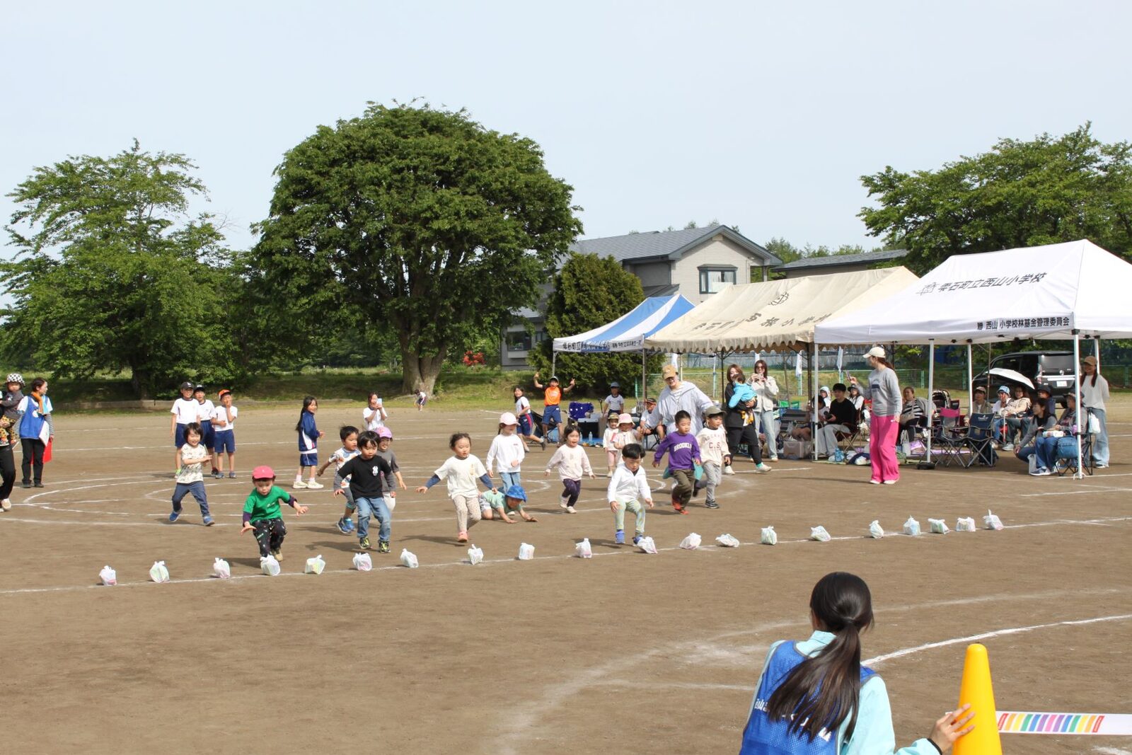 地面に置かれた景品袋に向かって走る未就学児たちの様子